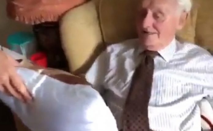 idoso chora ao receber de presente uma almofada com a fotografia da falecida esposa