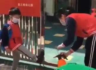 Crianças chinesas passam por desinfecção completa antes de entrarem na escola