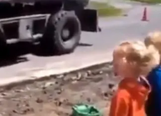 Operador de escavadora alegra crianças ao encher camiões de brincar com areia