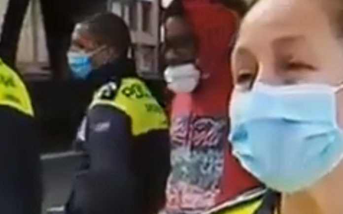 Polícia explica como usar máscara e jovem atrás mostra exactamente como não usar