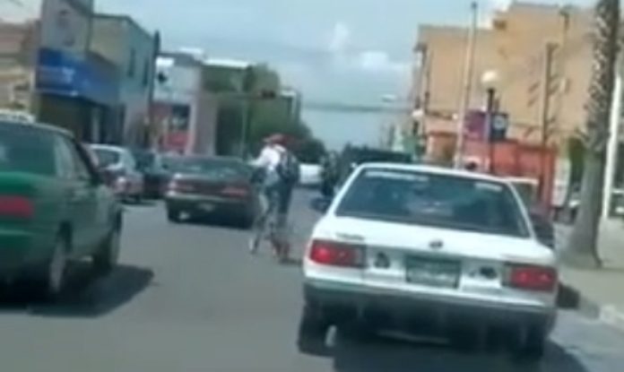 Condutor bate com porta do carro em ciclista que passava na estrada