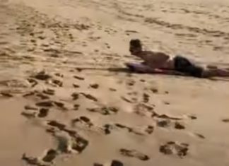 Jovem usa prancha de Skimming para deslizar de uma duna até ao mar