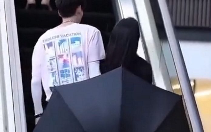 Jovem usa guarda-chuva para proteger namorada de olhares maldosos Jovem usa guarda-chuva para proteger namorada de olhares maldosos