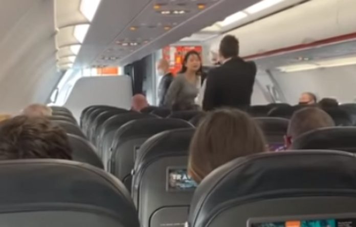 Mulher tosse para cima de passageiros depois de ter sido expulsa de avião por não usar máscara Mulher tosse para cima de passageiros depois de ter sido expulsa de avião por não usar máscara