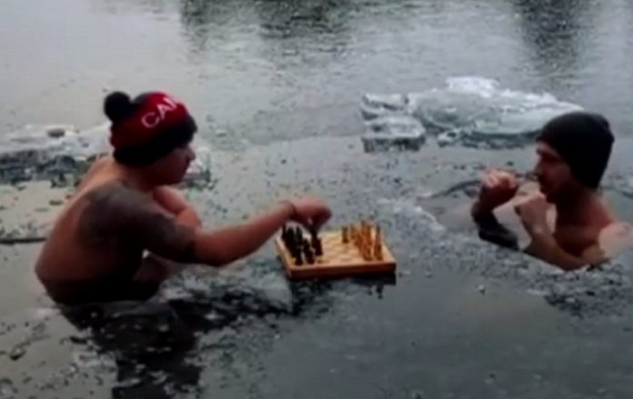 Dois amigos entram em lago gelado e jogam xadrez Dois amigos entram em lago gelado e jogam xadrez