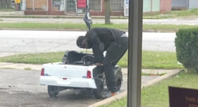 Homem anda pela cidade no carrinho de brincar