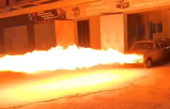 Mecânico altera os faróis do carro seu por uma lança-chamas