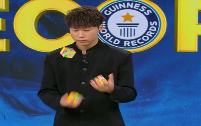 Mestre de quebra-cabeças chinês resolve três cubos de Rubik enquanto faz malabarismo