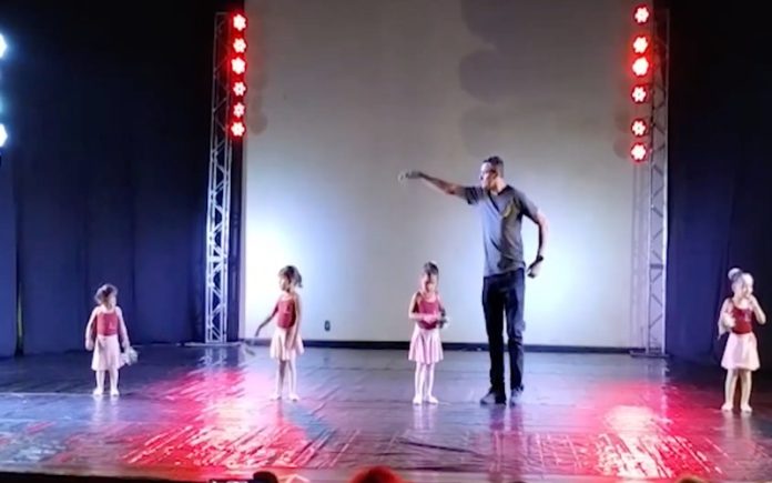 Pai sobe ao palco para e ajuda filha envergonhada a dançar balé
