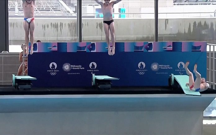 Mergulhador francês escorrega durante a performance de inauguração olímpica diante de Emmanuel Macron